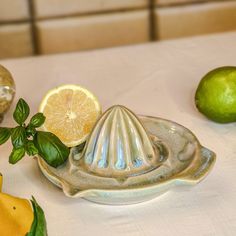 there are lemons and limes on the table next to each other, including an oyster shell