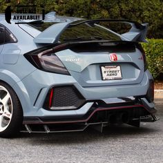 the rear end of a blue honda civic hatchback parked in front of some bushes