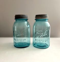 two blue mason jars sitting on top of a table