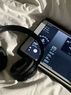 headphones and an iphone on a bed