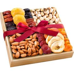 an assortment of nuts and dried fruits in a wooden box with a red ribbon on top