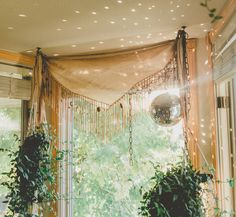 two potted plants sitting on top of a window sill next to a disco ball