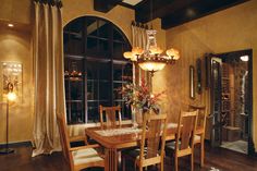 a dinning room table with chairs and a chandelier hanging from the ceiling