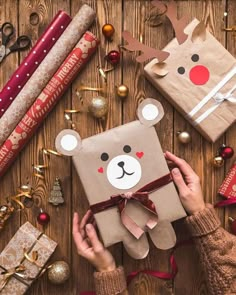 someone is holding a brown gift bag with a bear on it and other christmas decorations