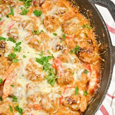 a skillet filled with shrimp and cheese covered in parmesan sauce on top of a red and white towel