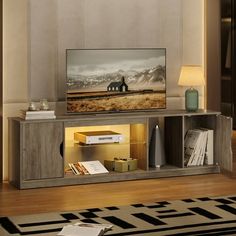 a flat screen tv sitting on top of a wooden entertainment center in a living room