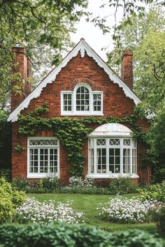 a red brick house with white windows surrounded by greenery