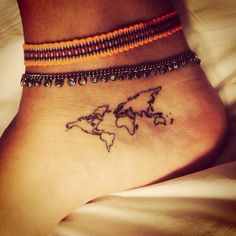 a small world map tattoo on the ankle