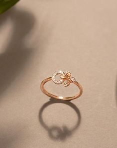 a gold ring sitting on top of a table next to a green leafy plant