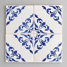 four blue and white tiles with designs on them