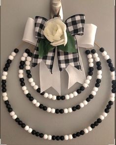 a black and white ribbon with a flower on it is attached to a wall decoration