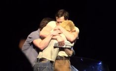 two men hugging each other on stage with one man holding the other in his arms