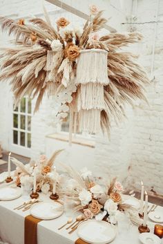 the table is decorated with flowers, candles and pamodia stalks for an elegant touch