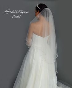 the back of a bride's wedding dress, with her veil draped over her shoulder