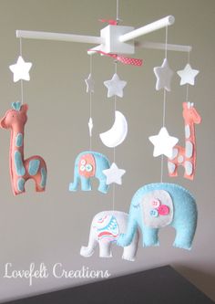 a mobile with elephants, giraffes and stars hanging from it