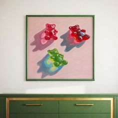 three teddy bears are sitting on top of a green dresser in front of a painting