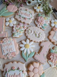 some decorated cookies are sitting on a table with flowers and other items in the background