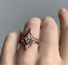 a woman's hand with a diamond ring on top of her finger and an engagement band