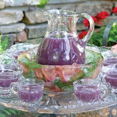 a pitcher and cups on a glass tray