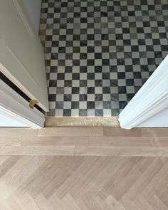 an open door with a black and white checkered floor