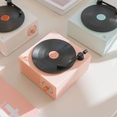 an old record player sitting on top of a table next to two other vinyl records