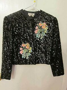 Vintage 1985 St Martin heavily sequined bolero jacket with beading and embroidery. Size Medium. Snaps down the front. Fairly heavy Shoulder pads. Embroidered and beaded flowers in the front of jacket and also in the back of the jacket. Shorter , bolero style. Catches the light!!!  VERY 80's COOL !!  There is  black beading all around the jacket. We notice a small amount of bead loss around the cuffs and a few beads missing around the very top of the beading in the back of neck are Vintage Black Embellished Outerwear, Vintage Beaded Outerwear For Spring, Beaded Vintage Outerwear For Spring, Spring Vintage Beaded Outerwear, Vintage Sequined Outerwear For Spring, Vintage Beaded Long Sleeve Outerwear, Bolero Jacket, St Martin, Beaded Flowers