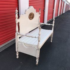 a white bench sitting in front of red storage units