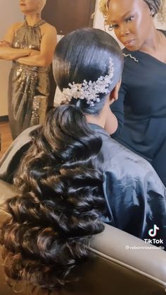 two women are getting their hair done at the same time as one woman looks on