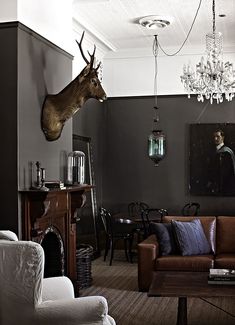 a living room filled with furniture and a deer head mounted to the wall above it