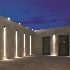 an empty room with several lights on the wall and doors to another room in the background