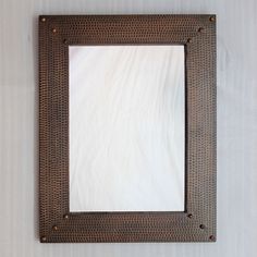 a square mirror mounted on the wall