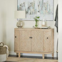 a living room with a large painting on the wall and a wooden cabinet in front of it