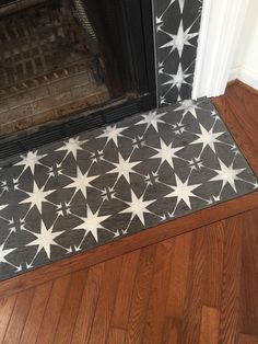 a black and white star pattern on the floor next to a fire place in a house