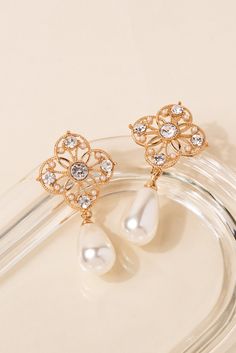 Are you someone that likes flowers, pearls, and jewelry? Then you've come to the right place! Our Metal Flower Pearl Drop earrings are the perfect combination of all those things, and they're made to impress! Perfect for all occasions, both formal and casual. Size Length: 2.25 in (5.72 cm)Width: 1.1 in (2.79 cm) QualityThese earrings are made of metal alloy with acrylic pearls and rhinestones placed all around the earring. They are fastened with a post backing mechanism. Imported EQ300 Flower-shaped Pearl Drop Earrings For Party, Pearl Flower-shaped Earrings For Party, Pearl Drop Earrings Gold, Pearl Shop, Holiday Essentials, Metal Flower, Pearl Set, Metal Flowers, Silver Drop Earrings