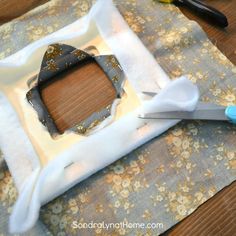 scissors are laying on top of a piece of fabric that has been cut into the shape of a rectangle