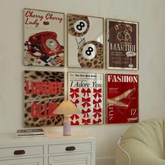 a white dresser sitting next to a wall with pictures on the wall and a lamp in front of it