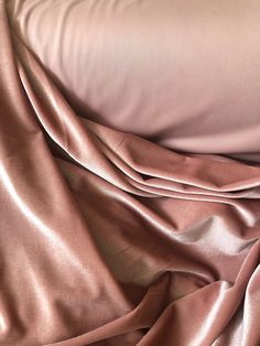 a close up view of a bed with pink sheets