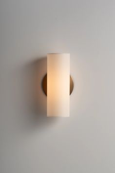 a light that is on the wall with a white shade over it's head