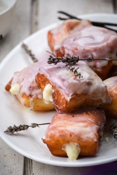 donuts with icing and lavender sprinkles on a white plate