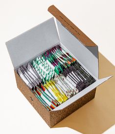 a box filled with lots of different colored toothbrushes on top of a table