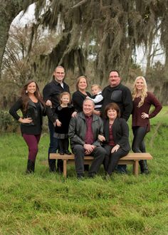 a family poses on a bench in front of some trees