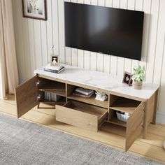 a flat screen tv sitting on top of a wooden entertainment center