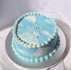 a blue and white birthday cake with clouds on it