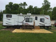 an rv is parked in the grass next to a picnic table