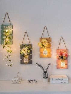 three hanging frames with flowers and candles on them