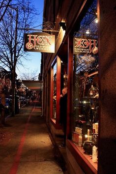 a store front with many items on display in it's windows at night time