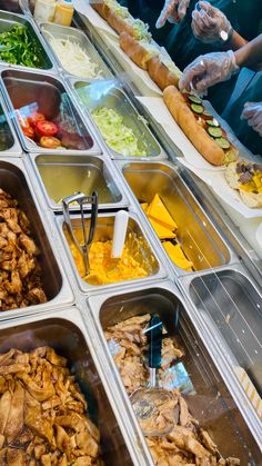 many trays of food that include meat and vegetables