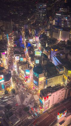 an aerial view of a city at night with lots of lights and buildings in the background