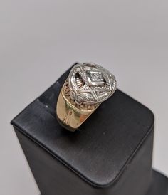 This ring is made of 10k white and yellow gold. The mounting is yellow with different inscriptions made into it. The Masonic symbol is in white gold and has a small round diamond set in the center. The face of the ring is 14mm wide and tapers down. Size 9, but can be resized up or down two sizes free of charge. Masonic Symbol, Masonic Symbols, Round Diamond Setting, Diamond Set, Round Diamond, Class Ring, Round Diamonds, Statement Rings, The Face