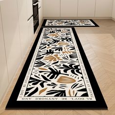 two black and white rugs on the floor in a kitchen next to an oven